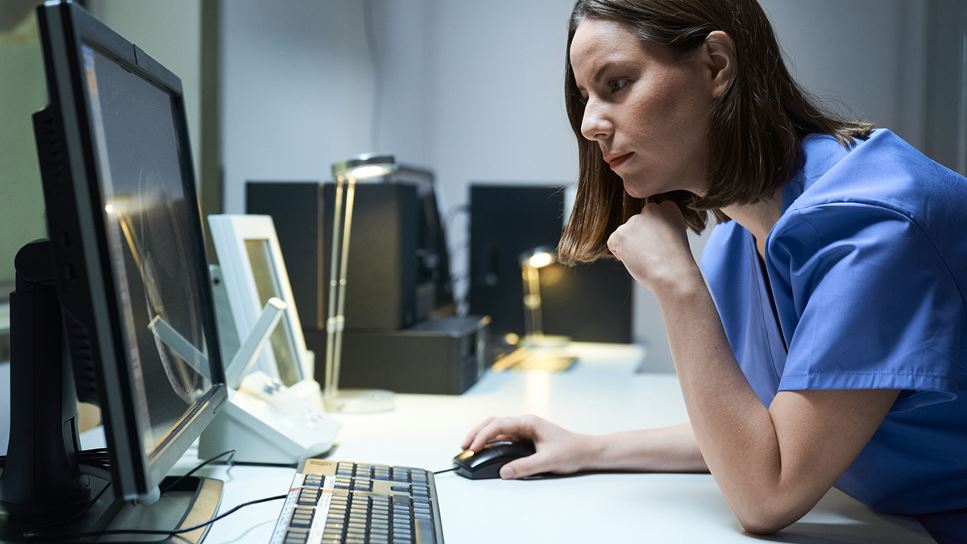 healthcare practitioner at computer in hospital